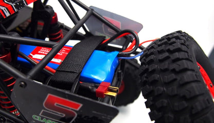 RC buggy interior with blue battery pack, red wires, and black chassis