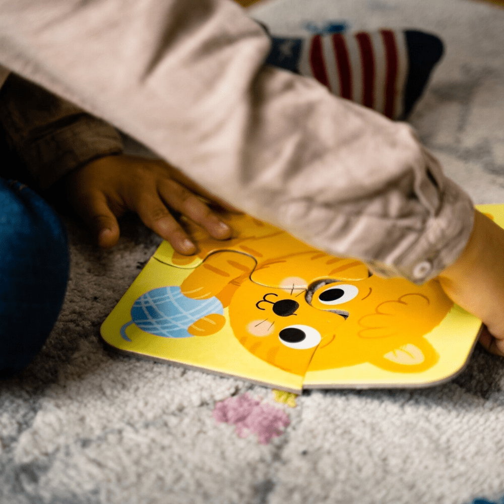 Yellow dog jigsaw puzzle pieces being placed by a child