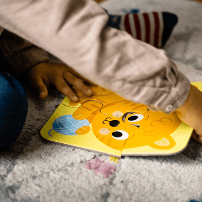 Yellow dog jigsaw puzzle pieces being placed by a child