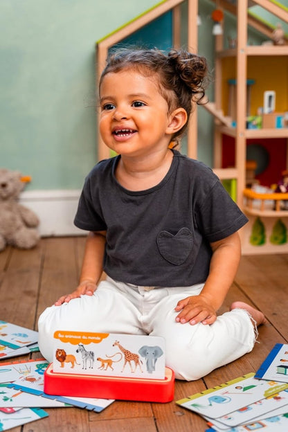 Enfant avec Mon Imagier Parlant : boîtier rouge et cartes d’animaux sur la table