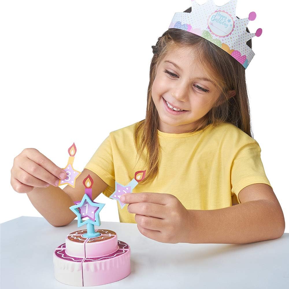 Toy birthday cake with colorful candles on stand, child playing with birthday set