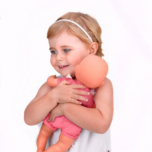New Born baby doll in pink romper with white lace bib, held by child