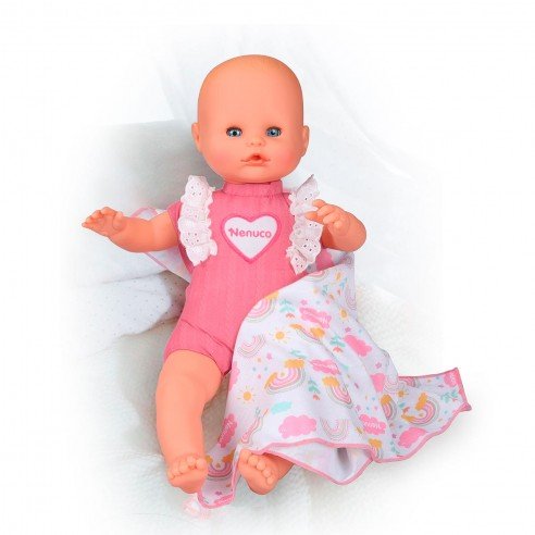 New Born baby doll reclining in pink outfit with white lace bib and rainbow print skirt