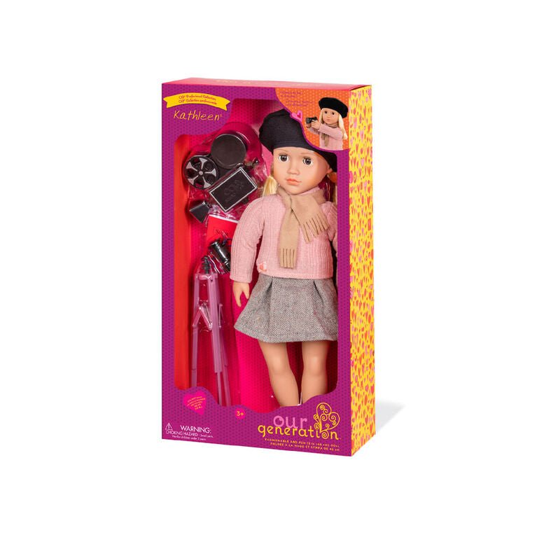Movie director doll in retail box, wearing black beret, pink sweater, and gray skirt.
