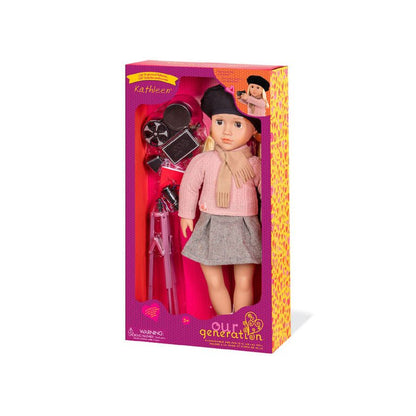 Movie director doll in retail box, wearing black beret, pink sweater, and gray skirt.
