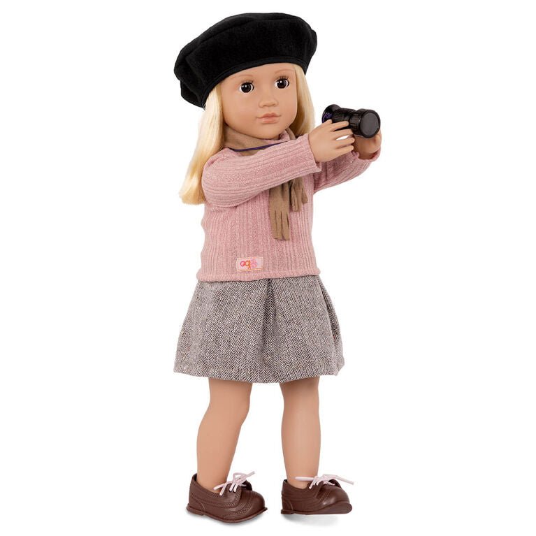 Movie director doll wearing black beret and pink sweater, holding a black camera prop.