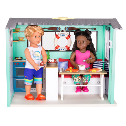 Seaside Beach House with two dolls at table, stove and lifebuoy behind