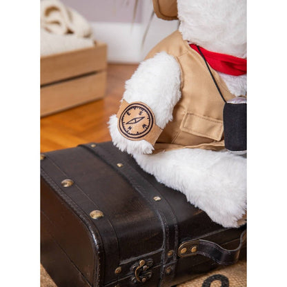 White bear plush arm with round patch, tan vest, and black satchel pouch