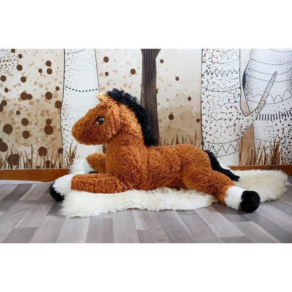 Plush horse sitting on a white blanket, tan fur with black mane and white muzzle.