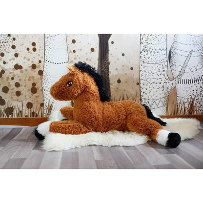 Plush horse sitting on a white blanket, tan fur with black mane and white muzzle.