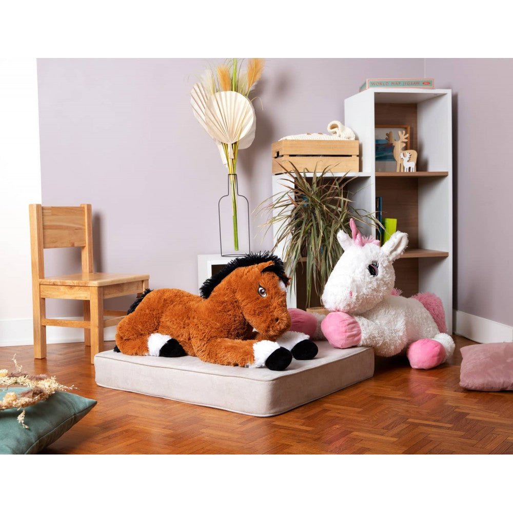 Plush horse lying on a cushion, tan fur with black mane and white feet.