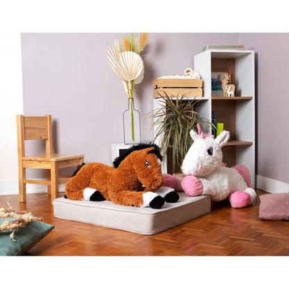 Plush horse lying on a cushion, tan fur with black mane and white feet.