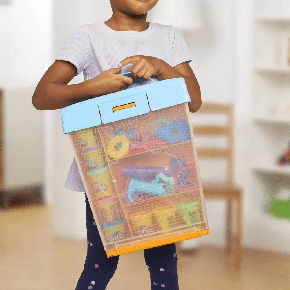 Transparent accessory box with orange lid, held by a child
