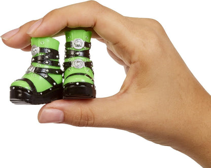 Green and black studded doll boots with high heel, held in a hand