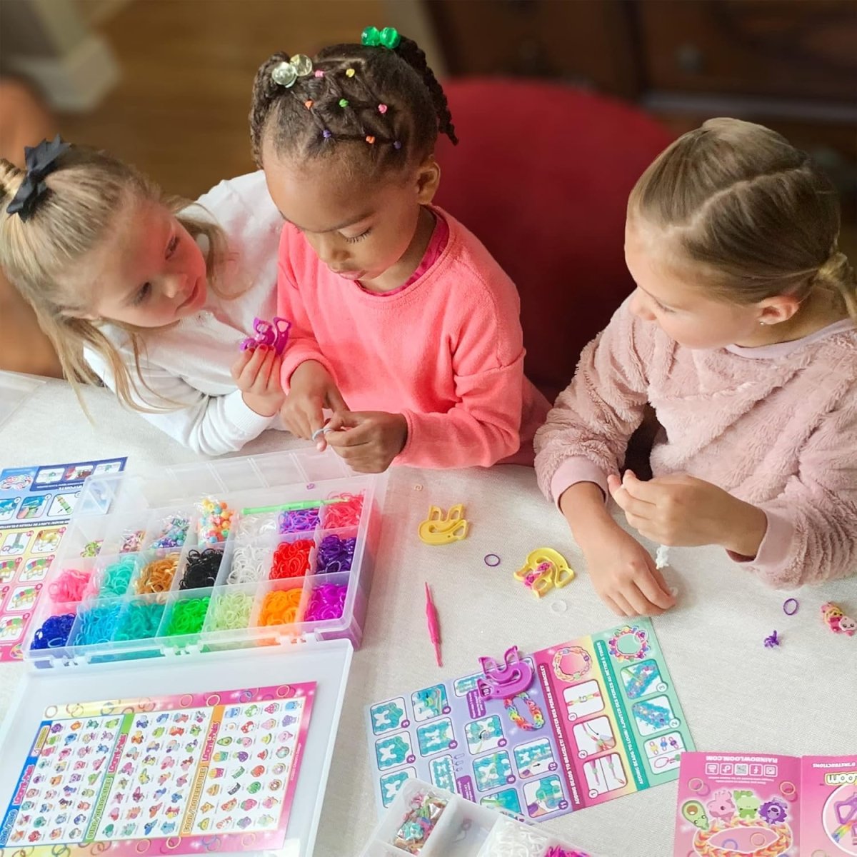 Kids making Loomi-Pals bracelets with rainbow loom kit on table