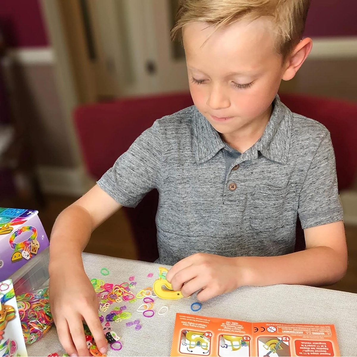 Child’s hands arranging colorful Rainbow Loom pieces on a beading mat
