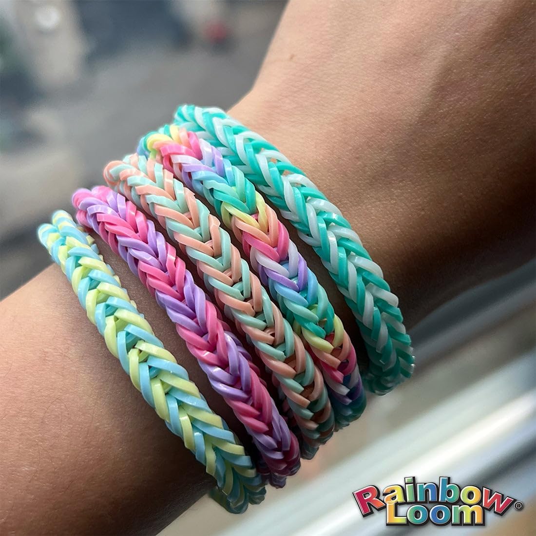 Pastellfarbiges Rainbow Loom Armband am Handgelenk, geflochtenes Muster