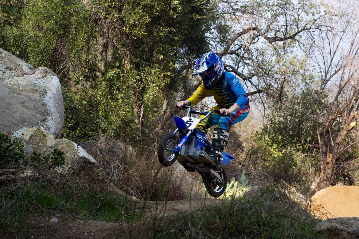 MX350 Dirt Rocket blue bike with number 5, ridden jumping on an off-road trail