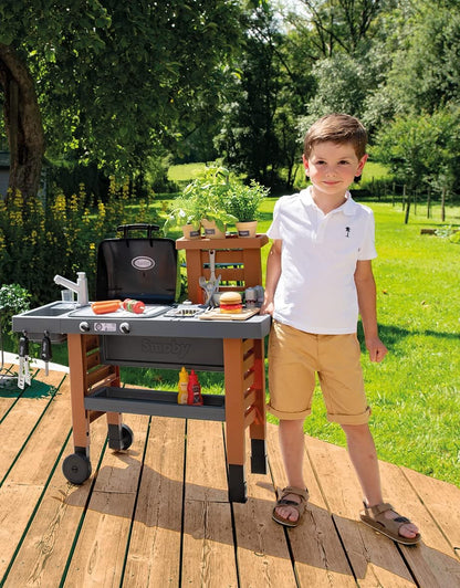 Outdoor garden kitchen play grill with gray counter, black hood, and side tool hooks