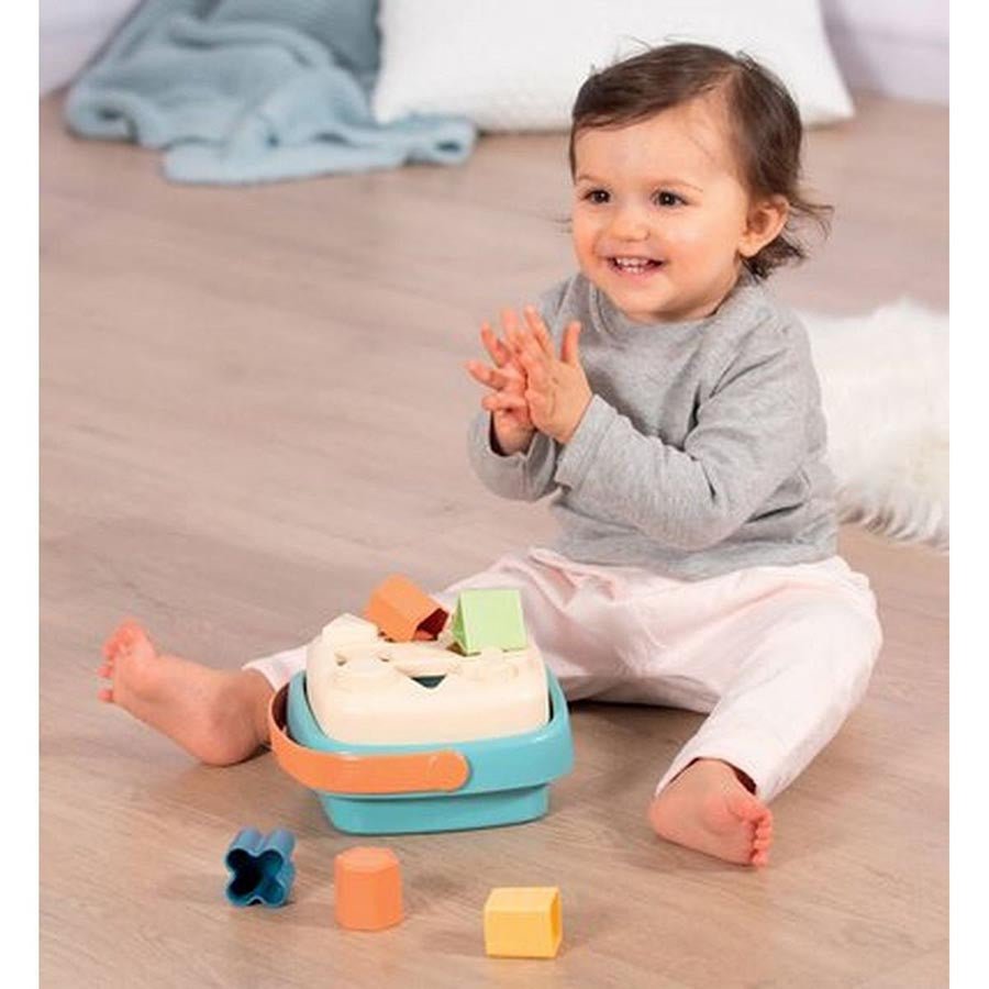 Bath set sailboat toy with blue base and orange sail, shown during toddler play