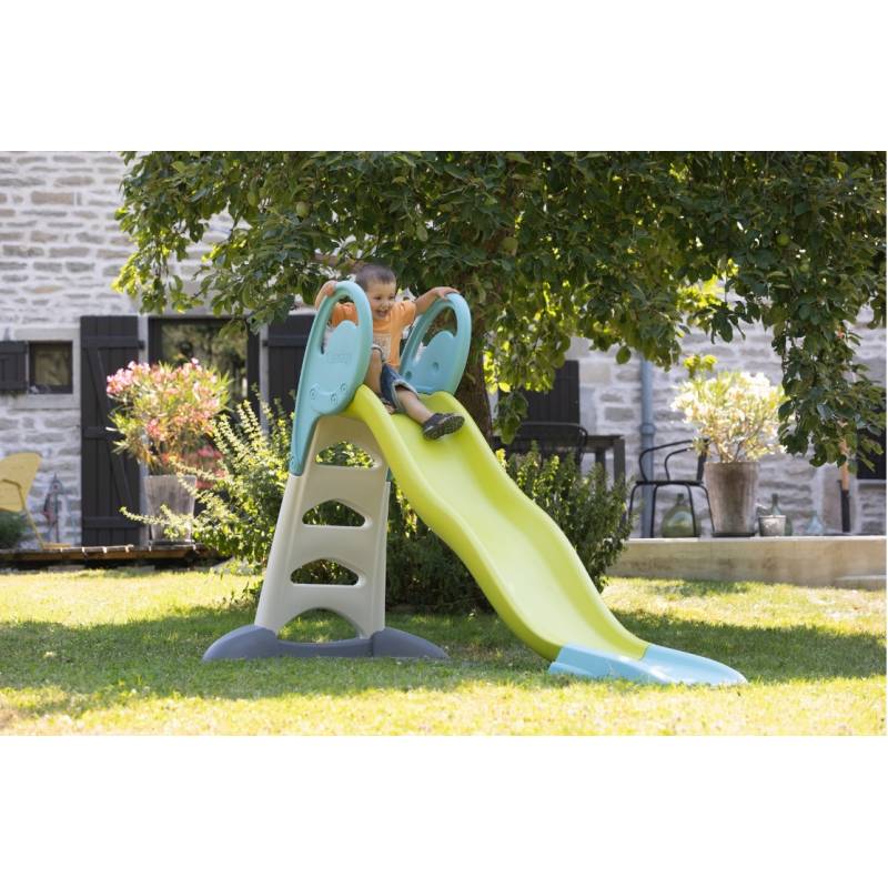 Playground slide outdoors with lime green chute and teal side rails
