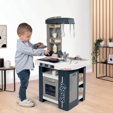 Tefal Studio Kitchen Spielküche im Einsatz, Kind kocht am Herd mit Pfanne