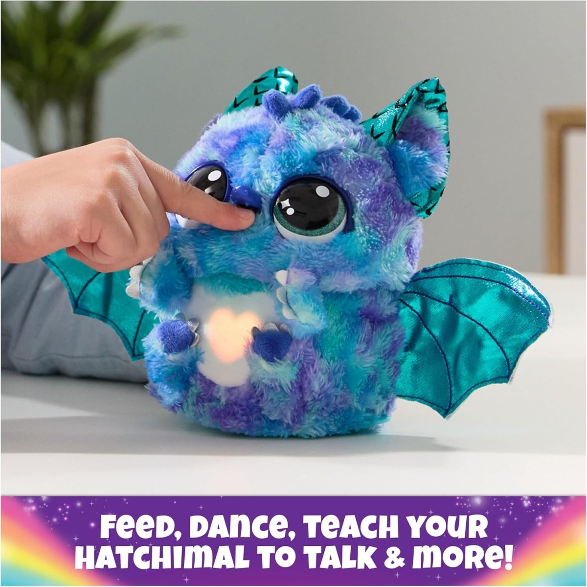 Blue and purple plush dragon with large eyes, teal wings, and light-up belly