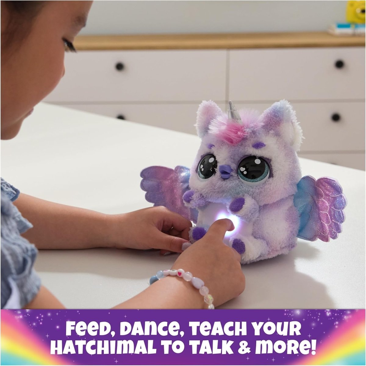 Purple and pink plush unicorn with wings and glowing light under belly